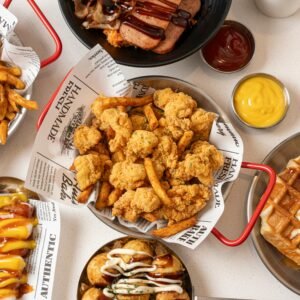Top view of assorted fast food dishes, including fried chicken, waffles, and fries.