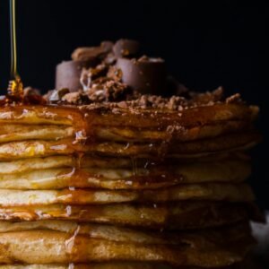 Mouthwatering stack of pancakes topped with chocolate and syrup. Perfect breakfast delight.
